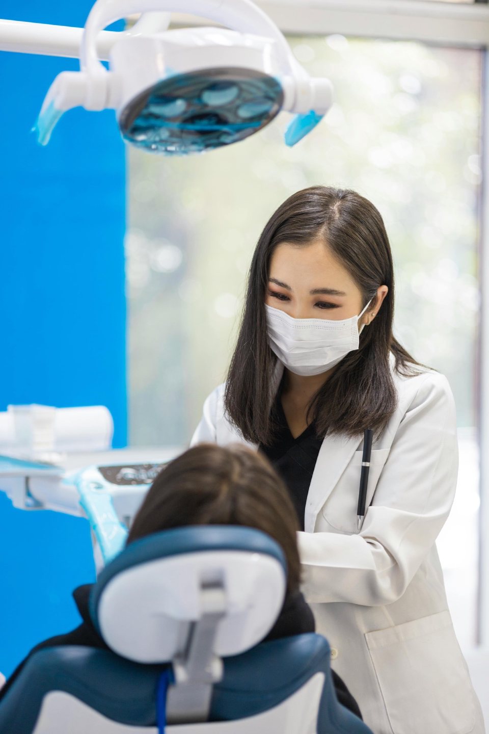Dental professional consulting with a patient in a bright operatory