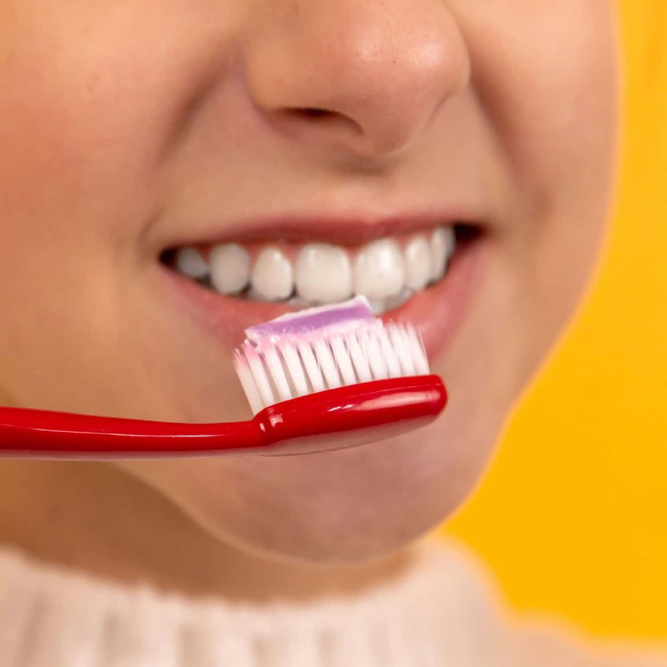 Close-up of a smiling person holding a toothbrush